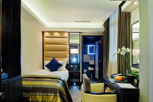 a hotel room with a bed and a desk at Park Grand Mayfair in London