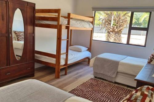 a room with two bunk beds and a window at Bestuis Cottage - Self catering accommodation on a farm in Klapmuts