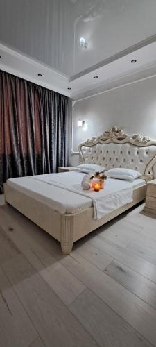 um quarto com uma cama grande com velas em Отличная квартира в центре Алматы, жилой комплекс Ush Qonyr em Almaty