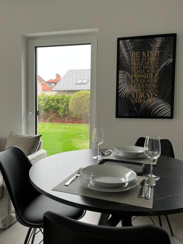Un comedor con mesa y sillas y una ventana. en Apartments Lily, en Liubliana