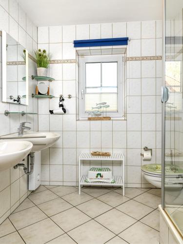 a bathroom with two sinks and a toilet and a window at Gollwitzer Park Seesternchen in Insel Poel