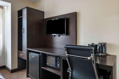 a hotel room with a desk with a tv and a chair at Sleep Inn Jacksonville Airport in Jacksonville