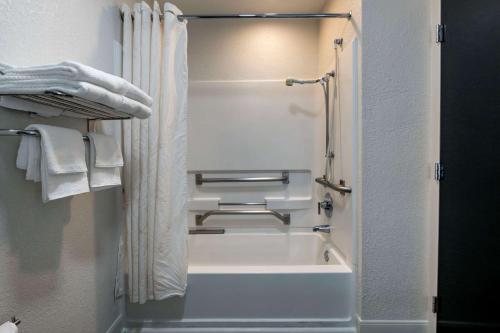 a bathroom with a shower and a bath tub at Sleep Inn Jacksonville Airport in Jacksonville