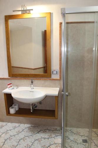a bathroom with a sink and a mirror and a shower at Suite Vista Mare in Santa Cesarea Terme