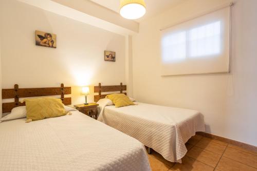 ein Schlafzimmer mit zwei Betten und einem Fenster in der Unterkunft Bahia 327 in Nerja