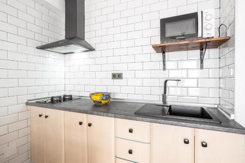 eine Küche mit einem Waschbecken und einem TV an der Wand in der Unterkunft Bahia 327 in Nerja