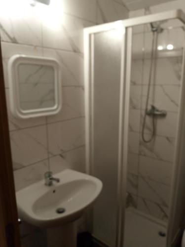 a white bathroom with a sink and a shower at Casa da Porta velha in São Gião