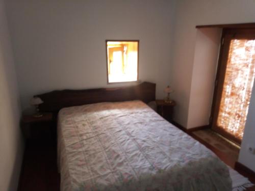 a bedroom with a bed and a window at Casa da Porta velha in São Gião