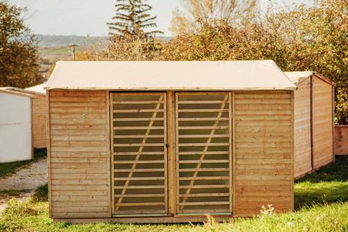 a wooden shed with a door in the grass at Event Lodge Glamping Spielberg in Spielberg