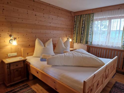 1 dormitorio con 1 cama con almohadas blancas en Haus Frei-Nagele en Alpbach