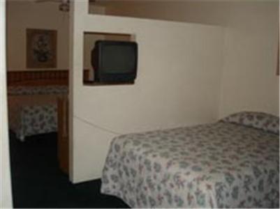 A bed or beds in a room at Colonade Motel Suites