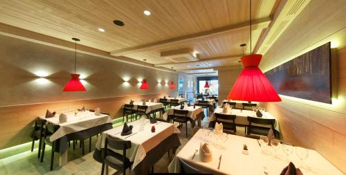 a restaurant with white tables and red lights at Hostal Pey in Bohí