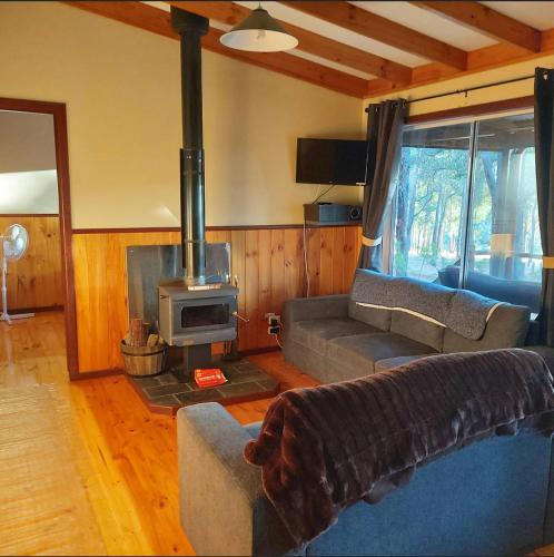 a living room with a couch and a stove at Balingup TimberTop Cottages in Balingup