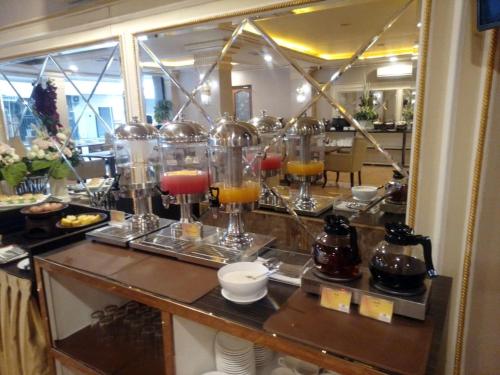 a bar with a bunch of drinks in glass jars at Olympic Hotel in Jakarta