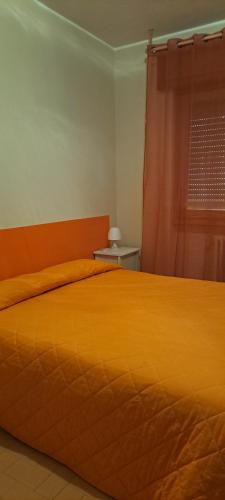 a bedroom with a orange bed and a window at Mondo D'Oro in Macugnaga