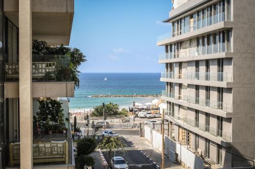 vistas al océano desde un edificio en Chic Apartment w Balcony, Mamad & Parking 3-min from Beach by Sea N' Rent en Tel Aviv