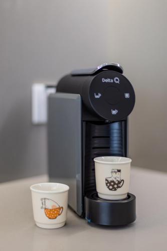a coffee maker with two cups on a counter at Pestana Apartments - Premium in Porto