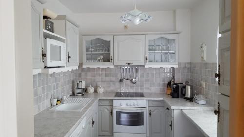 a white kitchen with white cabinets and a sink at Gemütliche Ferienwohnung in Annenheim