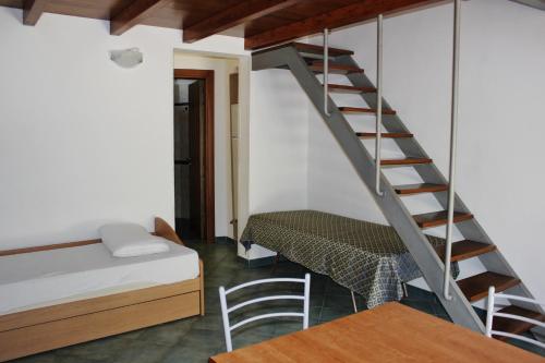 サンタ・チェザーレア・テルメにあるPalazzo De Donnoの階段、ベッド、テーブルが備わる客室です。