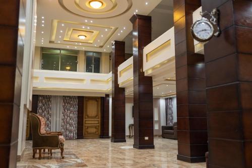 un vestíbulo de un hotel con un reloj en la pared en El Mina City, en ‘Izbat al Burj