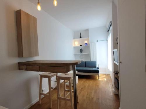 a kitchen with a table and stools in a room at Modern Design One Bedroom Apartment in Paris