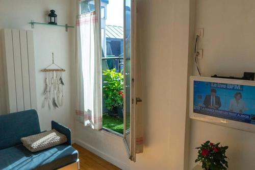 a living room with a blue couch and a window at Modern Design One Bedroom Apartment in Paris