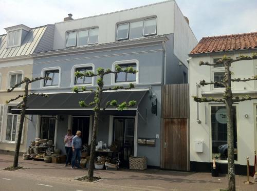 two people standing in front of a building at Hello Zeeland - Appartement Weststraat 14 in Domburg
