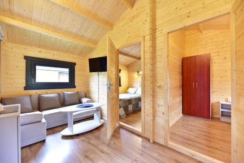 a living room with a couch and a bed at Nameliai Gulbės takas in Šventoji