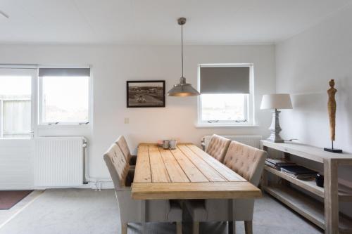 a dining room with a wooden table and chairs at Hello Zeeland - Appartement Weststraat 14 in Domburg