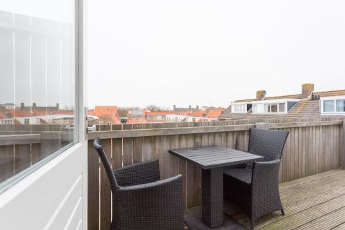 a table and chairs on a balcony with a view at Hello Zeeland - Appartement Weststraat 14 in Domburg