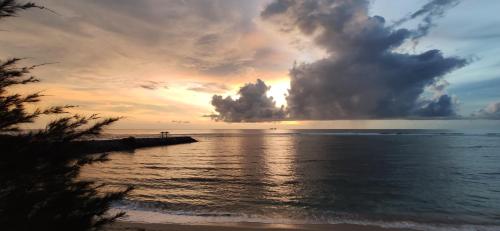 a sunset over the ocean with the sun setting at Eddie's Homestay in Lhonga