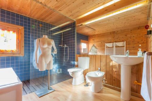 eine Puppe im Bad mit WC und Waschbecken in der Unterkunft GoToGeres - Casa da Piscina - Casas de Alem in Arcos de Valdevez