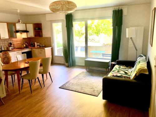 a living room with a couch and a table and a kitchen at Résidence Brocéliande in Saint Malo