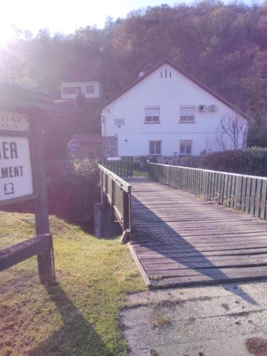 a wooden boardwalk leading to a white building at Pereszlényi Vendégház in Visegrád