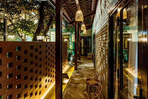 a hallway of a building with a table and chairs at Nana Homestay & Villa in Hue