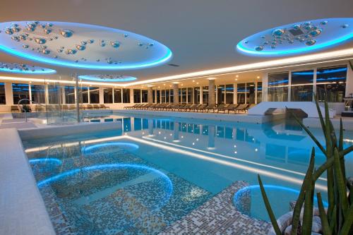 a swimming pool in a building with blue lights at Hotel Terme Venezia in Abano Terme