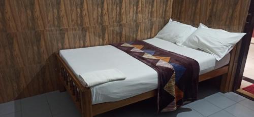 a bedroom with a bed with white sheets and pillows at RED LION in Varkala