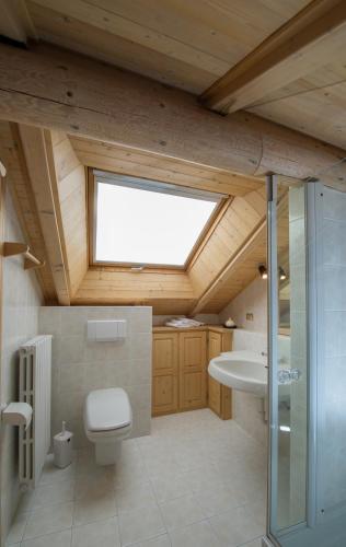 a bathroom with a toilet and a sink and a window at Chalet Terme Bormio in Bormio