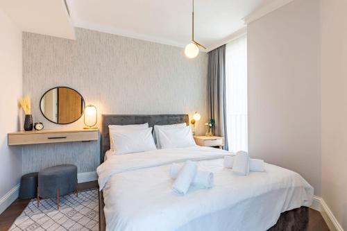 a bedroom with a large white bed and a mirror at Stylish Flat near Trendy Attractions in Beyoglu in Istanbul