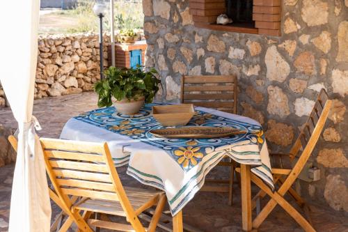 uma mesa com uma toalha de mesa azul e branca e cadeiras em Dammusi Ziunì em Lampedusa