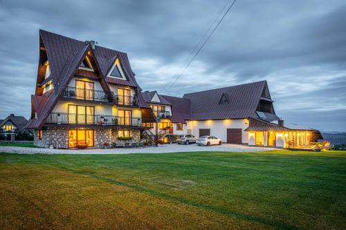 a large house with a large lawn in front of it at Wierchowa Chałupa in Ząb