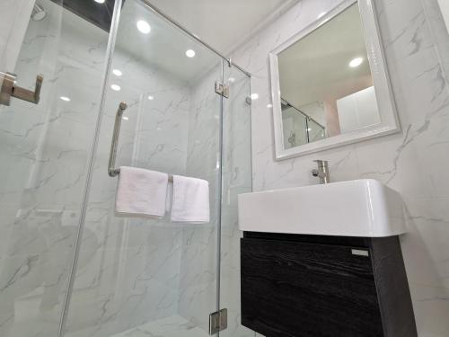 a white bathroom with a sink and a mirror at ABC@48 Hotel & Service Apartment in Bangkok