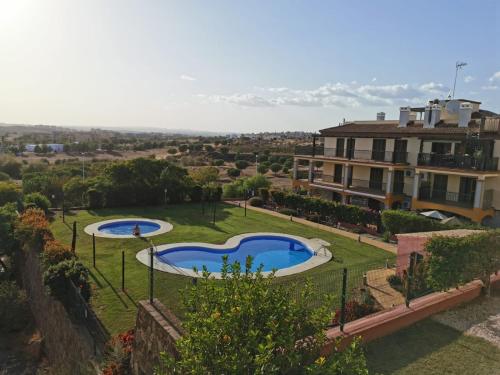 widok na dziedziniec z 2 basenami w obiekcie Finim Solis Apartamentos w mieście Ayamonte