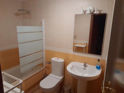 łazienka z toaletą, umywalką i lustrem w obiekcie Finim Solis Apartamentos w mieście Ayamonte