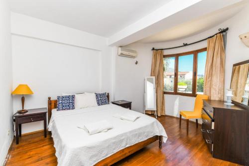 een slaapkamer met een bed, een bureau en een raam bij Duplex House with Shared Pool near Beach in Kalkan in Kalkan