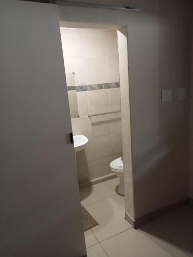 a bathroom with a toilet and a sink at Emampingeni lodge in Bizana
