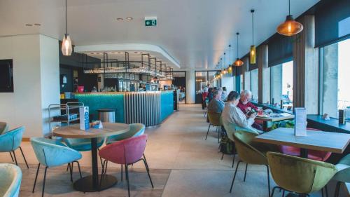a restaurant with people eating at tables and chairs at Vayamundo Oostende in Ostend
