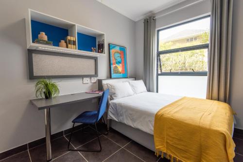 sypialnia z łóżkiem, biurkiem i oknem w obiekcie CampusKey Cape Town w Kapsztadzie
