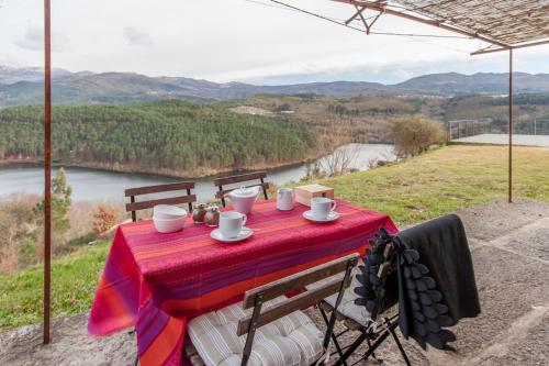 a table with a red table cloth on top of a mountain at GoToGeres - Casa do Lagar - Sobrenatura in Arcos de Valdevez