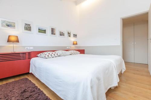 a bedroom with a white bed and a red headboard at GoToGeres - Casa do Lagar - Sobrenatura in Arcos de Valdevez